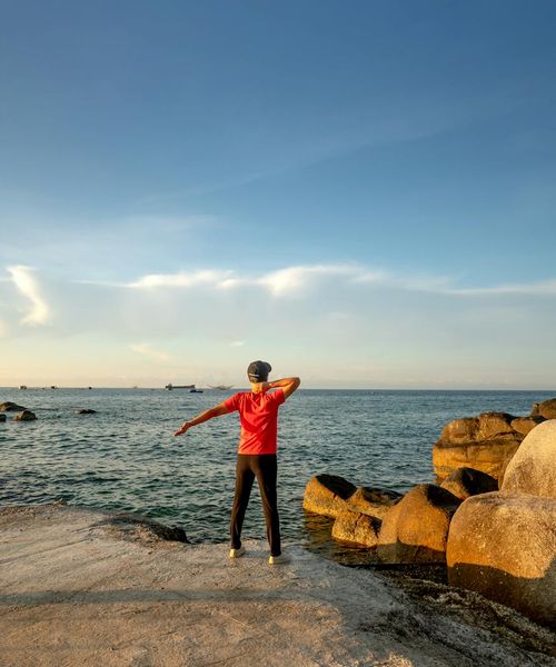 Silhouette of a person stretching during sunrise, full of energy.